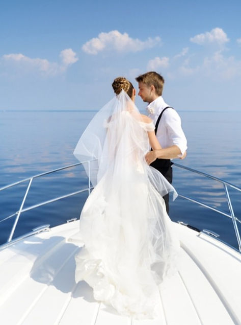 Teknede ayakta duran gelin ve damat fotoğrafı.